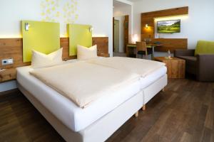 a large white bed in a hotel room at Hotel-Restaurant Bierhäusle in Freiburg im Breisgau