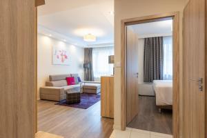 a hotel room with a bed and a living room at Silver Crown Hotel & Residence, Palace Quarter in Budapest
