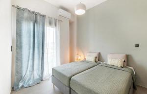 a bedroom with a bed and a large window at Eleusis Suites Β in Eleusis