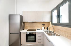 a kitchen with white cabinets and a stainless steel refrigerator at Eleusis Suites Β in Elefsina
