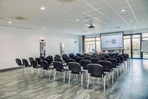 a conference room with chairs and a projection screen at Best Western Hôtel De La Cité & Spa in Guérande