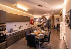 Optasia Luxury House في أرغوس: مطبخ وغرفة طعام مع طاولة وكراسي