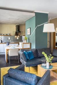 ein Wohnzimmer mit 2 Sofas und einer Küche in der Unterkunft The Green Rostock Apartment Hotel in Rostock