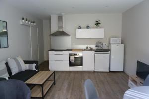 a kitchen with white appliances and a living room at Chez Berni in Millau