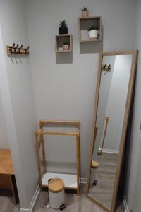een kleedkamer met een spiegel en een kruk bij Chez Berni in Millau