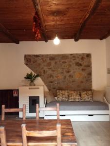 B&B ANDEMAR Rooms في Satriano di Lucania: غرفة بها طاولة وكراسي وجدار حجري
