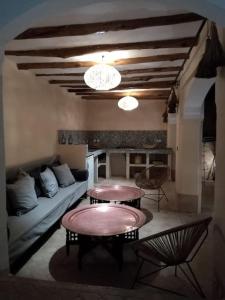 ein Wohnzimmer mit zwei Tischen und einer Couch in der Unterkunft Dar Nassima in Marrakesch + 22 Fotos