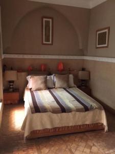 een slaapkamer met een groot bed met 2 lampen bij Dar Nassima in Marrakesh