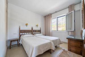 a bedroom with two beds and a window at Apartamentos Costamar in Lloret de Mar