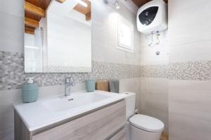 a bathroom with a sink and a toilet and a mirror at Casa Maria with Roque Nublo view in Tejeda