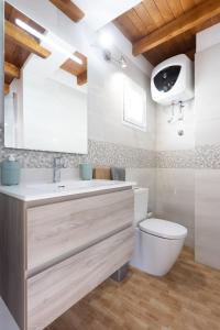 a bathroom with a white toilet and a sink at Casa Maria with Roque Nublo view in Tejeda