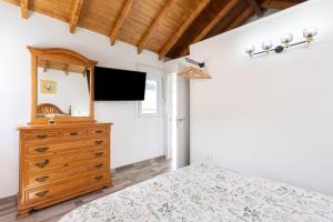 1 dormitorio con 1 cama y TV en la pared en Casa Isabela with Roque Nublo view, en Tejeda