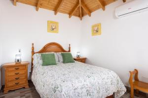 a bedroom with a large bed and a wooden dresser at Casa Isabela with Roque Nublo view in Tejeda