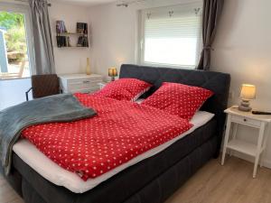 een slaapkamer met een bed met rode kussens bij Ferienwohnung Dick in Schmallenberg