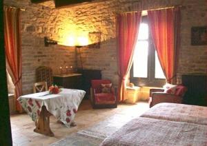 een slaapkamer met 2 bedden en een tafel in een kamer bij Auberge de La Halle in Cordes-sur-Ciel