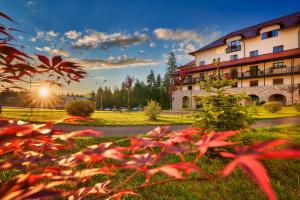 vista di un edificio con fiori rossi in primo piano di Ana Hotels Sport Poiana Brasov a Poiana Brasov