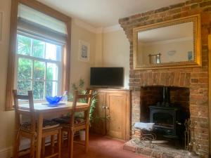 a dining room with a table and a fireplace at Minty Cottage in Hythe