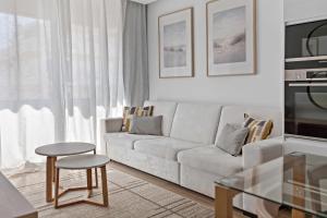 a living room with a white couch and a table at Timeless Sea III Apartment in Armação de Pêra