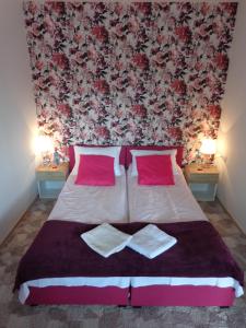 a bedroom with a large bed with red and pink pillows at Noclegi-SKAŁKA in Olsztyn
