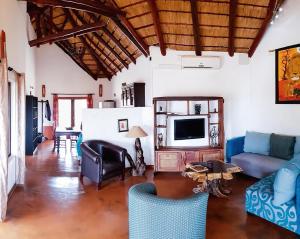 a living room with a couch and a tv at Game Lodge bordering Kruger with splash pool in Phalaborwa