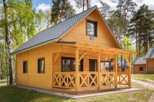 a log cabin with a gambrel roof at Ośrodek Wypoczynkowy Laguna in Lubniewice