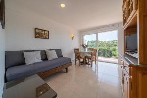een woonkamer met een bank en een tafel bij Apartamentos Costamar in Lloret de Mar