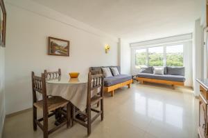 een woonkamer met een tafel en een bank bij Apartamentos Costamar in Lloret de Mar