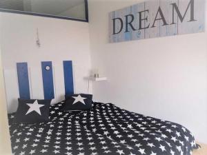 ein Bett mit schwarzen und weißen Kissen und einem Traumschild in der Unterkunft Apartementhaus Panoramic in Sierksdorf