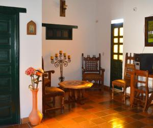 een eetkamer met een tafel en stoelen en een vaas met bloemen bij Hotel Antonio Nariño in Villa de Leyva
