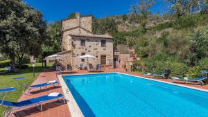 a house with a swimming pool in front of a building at LE GRAZIE 8, Emma Villas in Montepulciano