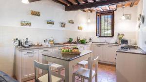 a kitchen with a table with a bowl of fruit on it at LE GRAZIE 8, Emma Villas in Montepulciano