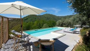 piscina con ombrellone e sedie accanto a piscina di VILLA CRISTINA 3, Emma Villas a Marliana