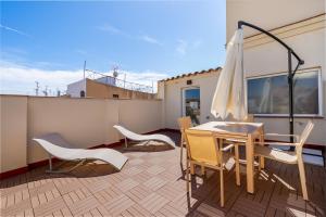a patio with a table and chairs and an umbrella at Apartamentos Circo Romano in Tarragona