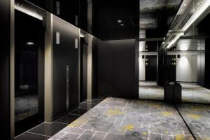 a hallway with black walls and a tiled floor at KOKO HOTEL Premier Kumamoto in Kumamoto