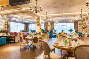 a restaurant with tables and chairs and windows at Forest resort BalQaragai in Malotimofeyevka