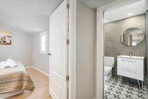 a bathroom with a bed and a sink and a mirror at Apartamentos Circo Romano in Tarragona +112 photos