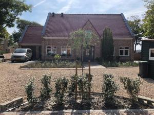 a house with a bunch of plants in front of it at Westkapelle comfortabele Strandkamer aan de Kreek in Westkapelle