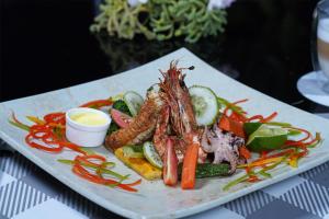 um prato de alimentos com caranguejos e vegetais numa mesa em MOONSHELL RESIDENCE em Baa Atoll
