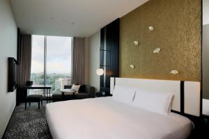 熊本KOKO HOTEL Premier Kumamoto的一间配有白色床和书桌的酒店房间