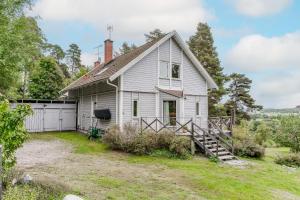 une vieille maison blanche avec un garage dans l'établissement Architect-designed house in Jarna with fantastic views, à Järna