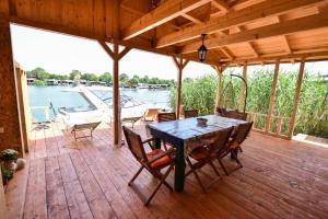 une terrasse en bois avec une table et des chaises sur un bateau dans l'établissement Sojenica Tamara, à Ulcinj