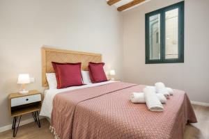 a bedroom with a large bed with red and white pillows at Apartamentos Circo Romano in Tarragona
