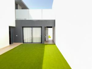 Una casa con un césped verde delante de ella. en OCEAN VIEW Lajares, en Lajares