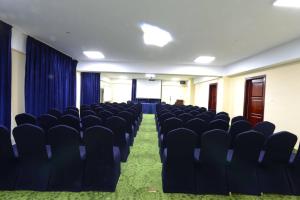 an empty conference room with chairs and a screen at Alpha Hotel Mongolia in Ulaanbaatar