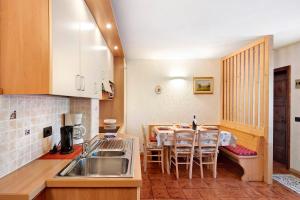 a kitchen with a table and a dining room at Residence Attila Giardino in Livigno