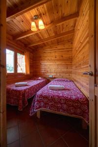 a room with two beds in a wooden cabin at Camping Els Ports in Arnés
