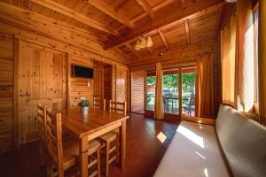 a dining room with a wooden table and chairs at Camping Els Ports in Arnés