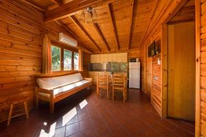 a log cabin with a kitchen and a bed in it at Camping Els Ports in Arnés