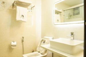 Baño blanco con lavabo y aseo en MOONSHELL RESIDENCE, en Atolón Baa