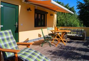 een patio met een tafel en stoelen en een parasol bij Apartment Sonnenschein in Weimar